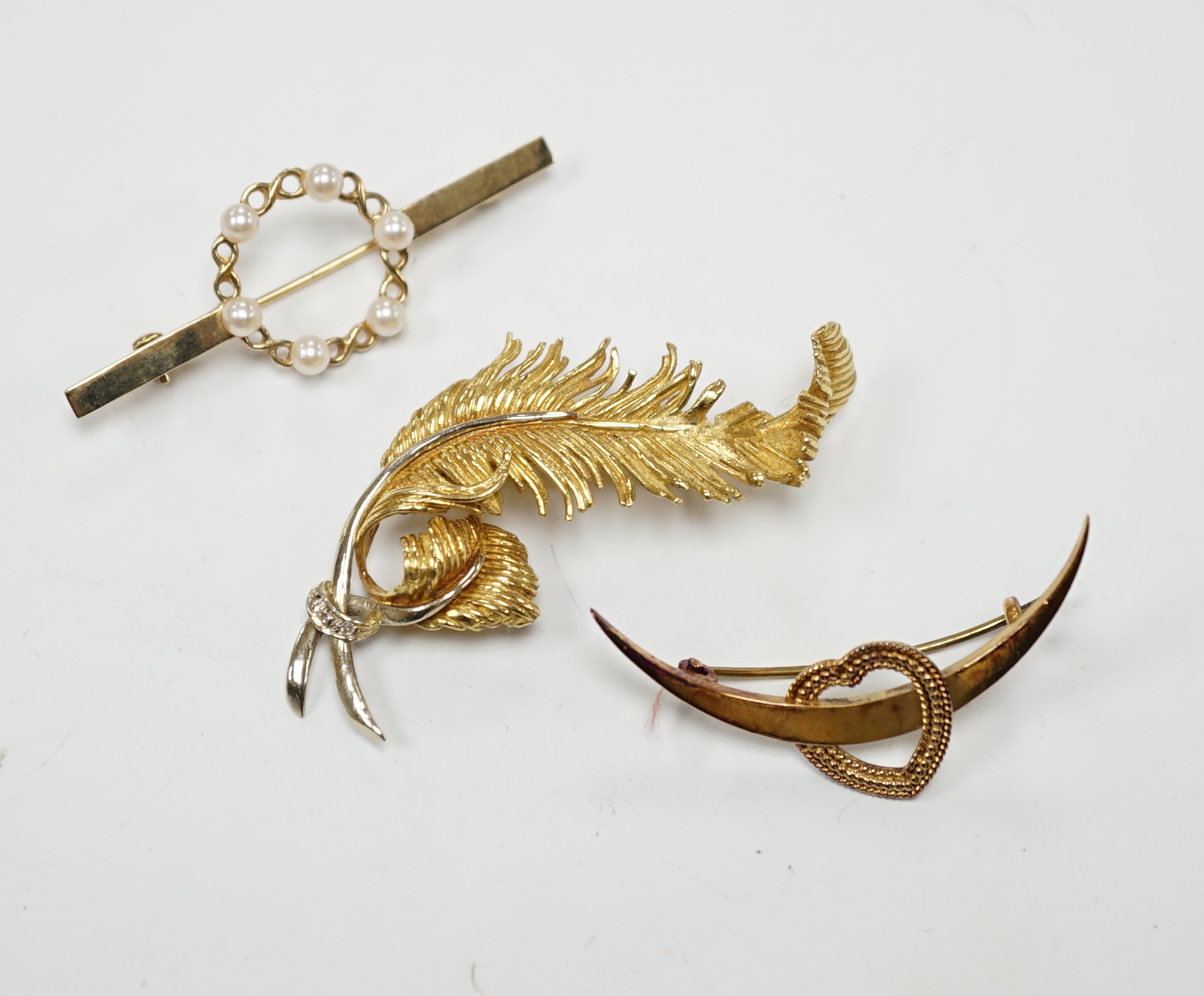 A 1960's 18ct gold and diamond chip set scrolling fern brooch by Cropp & Farr, 52mm, an 18ct heart and crescent brooch, gross weight 11.9 grams and a 9ct and seed pearl bar brooch, gross weight 2.8 grams.